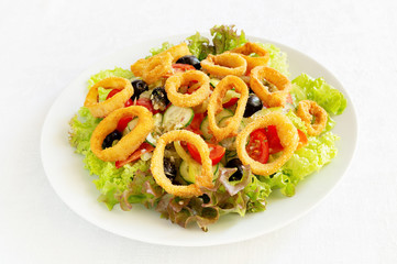 breaded calamari salad with tomato, cucumber, olives, bell pepper, and lettuce dressed with lemon juice and olive oil based mixture