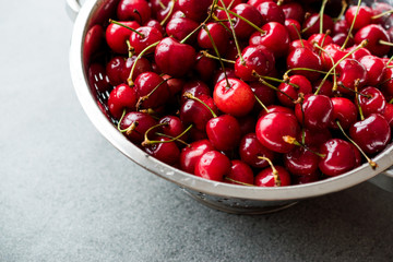 Raw Red Organic Cherries in Metal Collander.