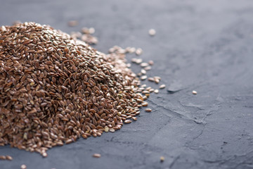 Flax seeds in a pile on a dark background. Concept healthy diet with omega 3 fatty acids.
