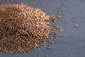 Flax seeds in a pile on a dark background. Top view. Healthy diet with omega 3 fatty acids.