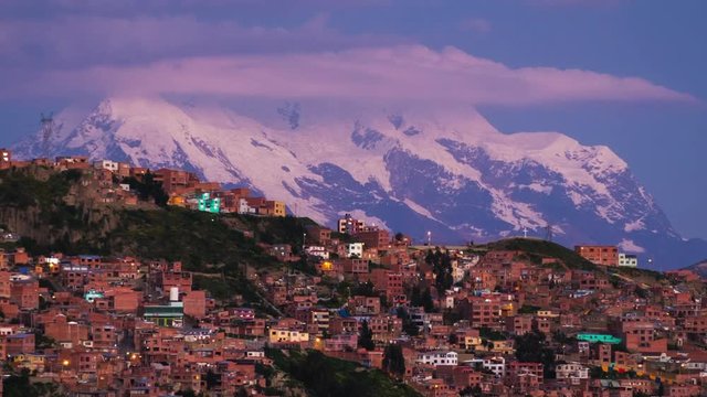 Zoom out timelapse of the city of La Paz and mountain of Illimani at sunset, Bolivia