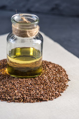 Flax seeds and linseed golden oil in a glass bottle on the table. Healthy diet with omega 3 fatty acids.