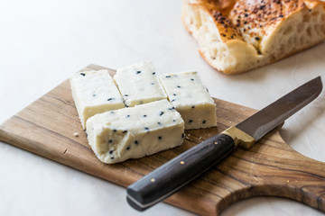 Turkish Feta Cheese with Black Cumin (Sesame) Seeds on Wooden Surface with Knife.