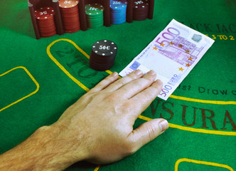 500 Euro note being exchanged for gaming chips on a green felt Blackjack table at the casino