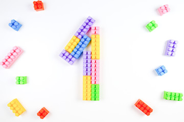 Colorful plastic blocks forming the number one on white background