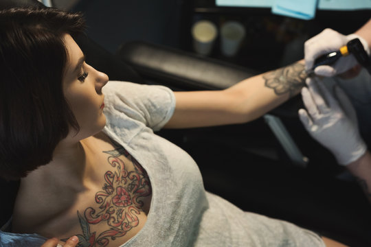 Professional tattoo artist making tattoo on hand