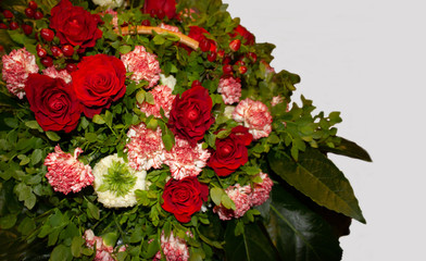 Basket with different blooming flowers and greens