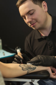 Professional tattoo artist making tattoo on hand