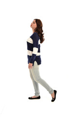 full length portrait of girl wearing striped blue and white jumper and jeans. standing pose on white studio background