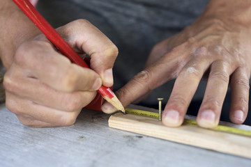 Obraz premium young man making a mark in a wood strip