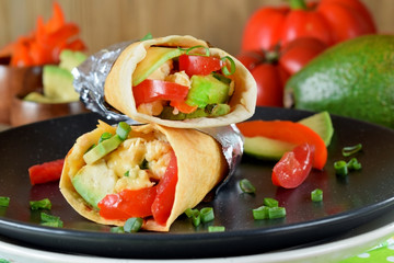 Burrito with vegetables and fried eggs. Mexican cuisine meal