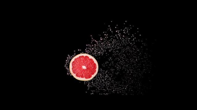 Concept of fresh cold grapefruit citrus drink and fresh juice. Grapefruit slice, half rotating in cold water or juice drops, splash, flow. Copy space.