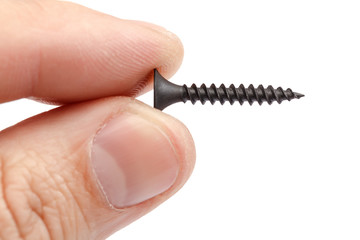 Metal self-tapping screw in the hand, on white background.