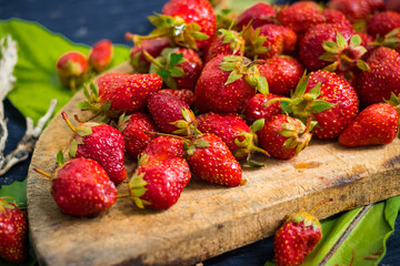 Ripe and sweet strawberry on rustic wooden board. Farm harvest of organically grown product for healthy life full of summer vitamins.
