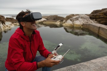 Man operating a flying drone while using virtual reality headset