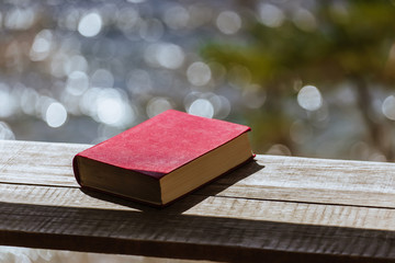Closed book lies on a bench in nature