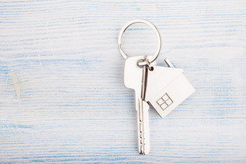 House key with trinket house on a wooden background