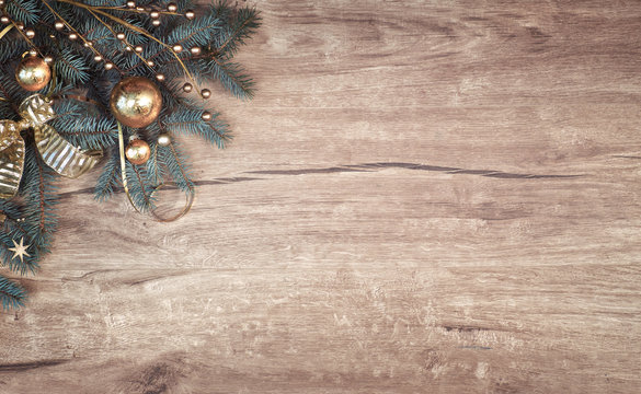 Christmas background on wood with a corner of decorated fir tree branches, copy-space