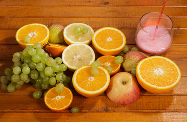 Grapes, lemon, orange,Apple, pear cut into slices on a wooden background.