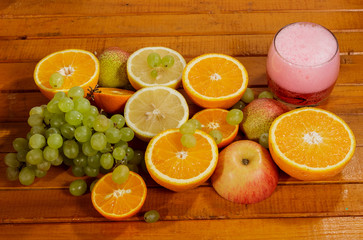 Grapes, lemon, orange,Apple, pear cut into slices on a wooden background.