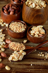 Whole and shredded peanuts in wooden bowls