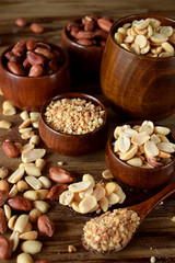 Whole and shredded peanuts in wooden bowls