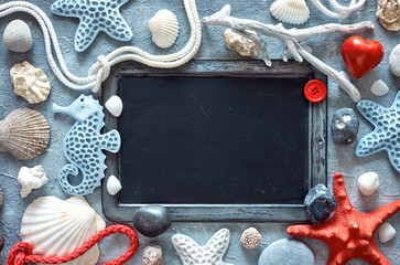Blank blackboard with sea shells, stones, rope and star fish on textured light blue background