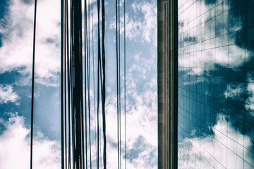 Clouds in a blue sky reflected in glass windows of an office building