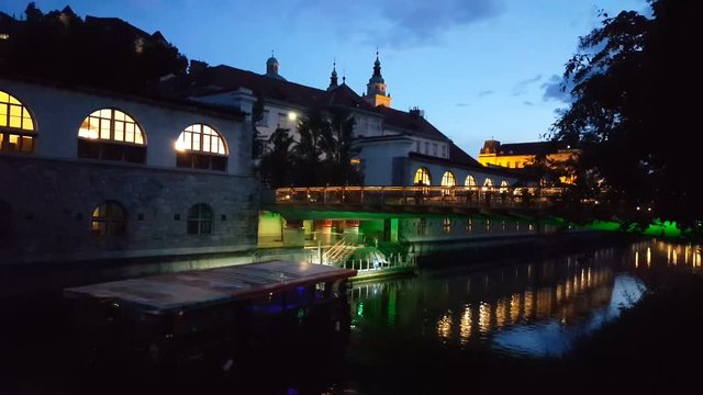 Tourist boat floating on Ljublanica river at night, Slovenia