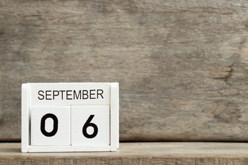 White block calendar present date 6 and month September on wood background