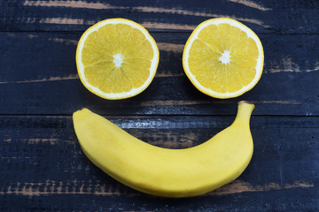 orange and banana lie on the table in the form of a smile