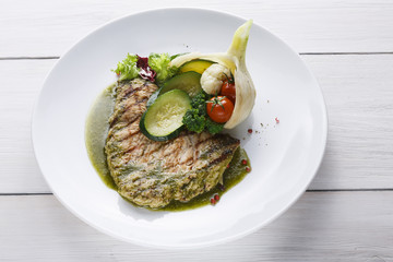 Perfectly seasoned grilled beefsteak served with vegetables and sauce