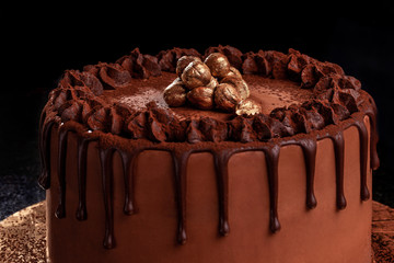 Chocolate cake with nuts on a black background. Close-up