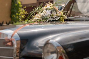 Oldtimer Auto 280SE Coupe mit Brautstrauß und Blumen für Hochzeit geschmückt.