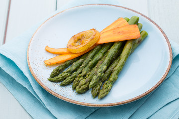 Fried asparagus with broccoli and lemon and carrot.