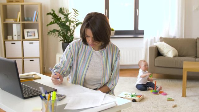 multi-tasking, freelance and motherhood concept - working mother with baby boy at home office