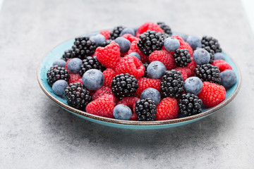 Fresh raspberries in a plate on a  vintage background.
