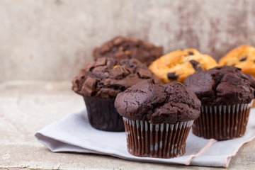 Homemade muffins with chocolate, vintage background.
