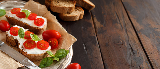 Bruschetta with cream cheese, cherry tomatoes and basil
