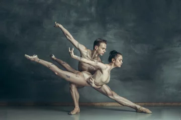 Fotobehang The young modern ballet dancers posing on gray studio background © master1305