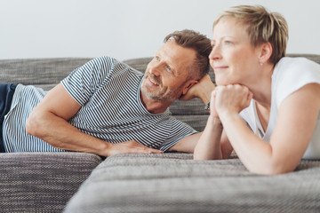 Couple relaxing at home on a sofa watching TV