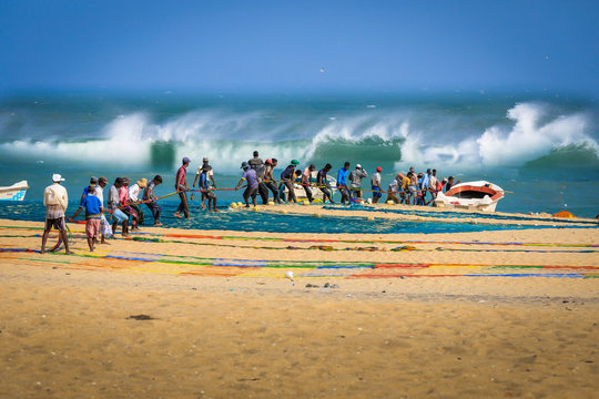 Eine Gruppe von Fischern vor der Küste von Sri Lanka ziehen Fischernetze an den Strand