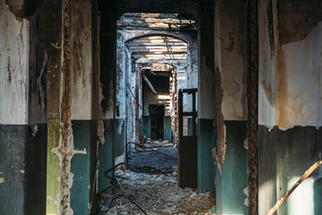 Fototapeta na wymiar Abandoned ruins of house after disaster, tunnel, corridor without doors