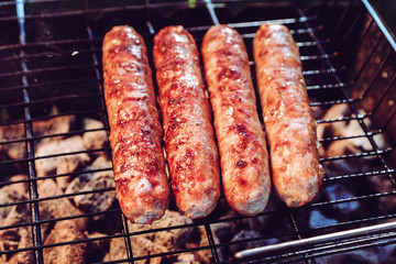 Grilling sausages on BBQ. Juicy beef. camping