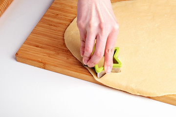 the process of making christmas cookies, raw dough, rolling pin and baking star forms.