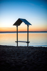 Bench on the lake during sunset in summer