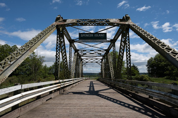 An old bridge with metal trusses spans a river