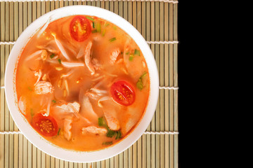Tom Yum Gai or spicy tom yum soup with chicken - Authentic Thai style food. With ingredients: lemongrass, galangal, kaffir lime leaves, fresh chilies, and lime.