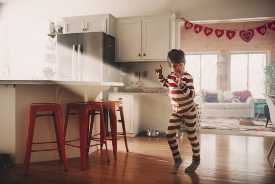 Boy dancing in the kitchen in his pyjamas