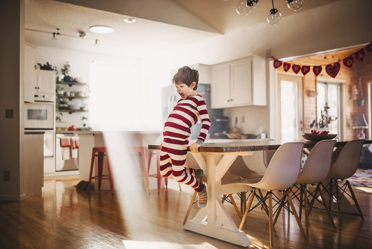 Boy jumping off a dining room table